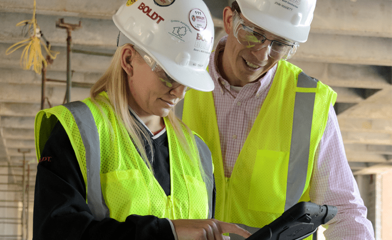 Two Construction Employees Review Item on Tablet