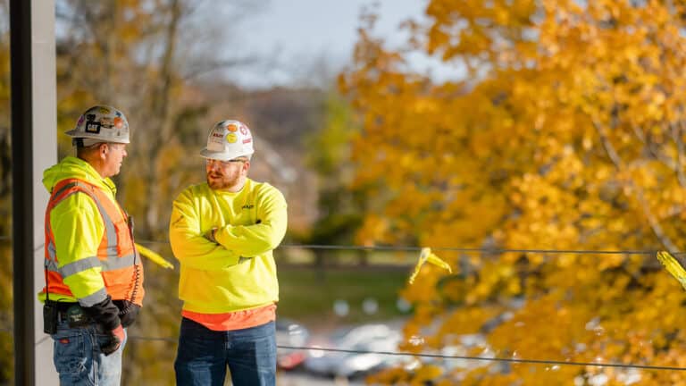 Two Boldt team members having a conversation near an autumnal tree