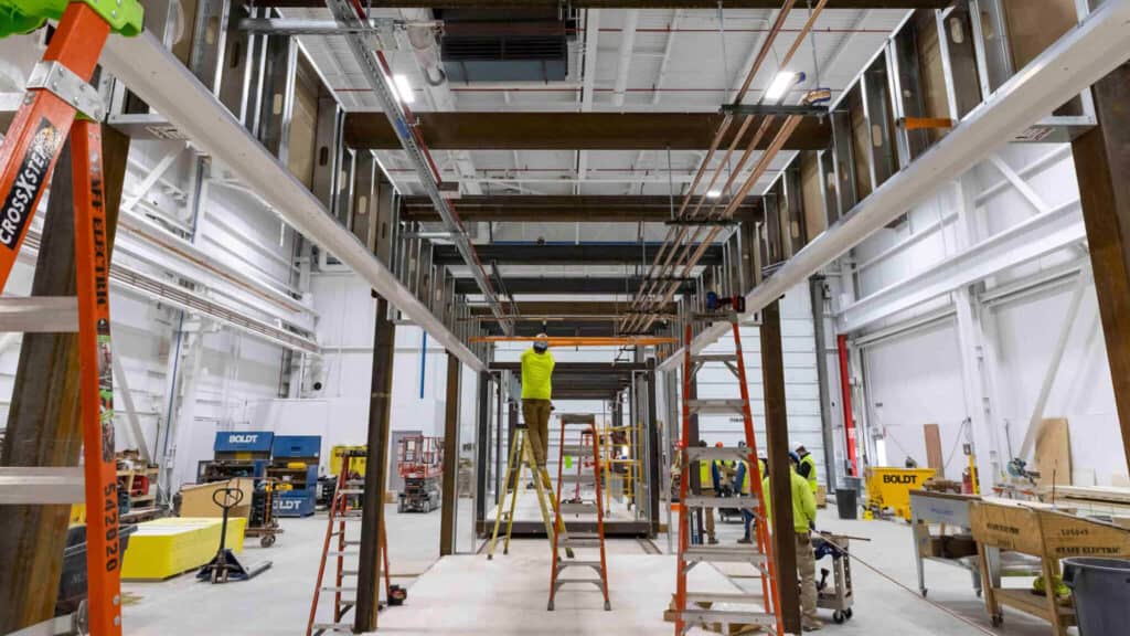 Team members working on metal structure in warehouse