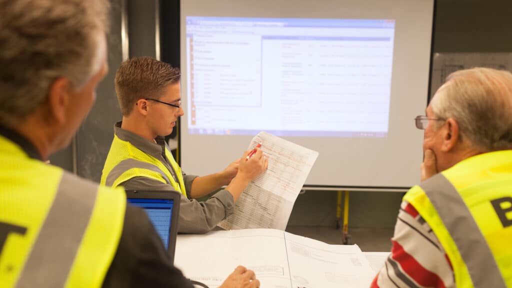 Boldt team members discussing at table with presentation on screen