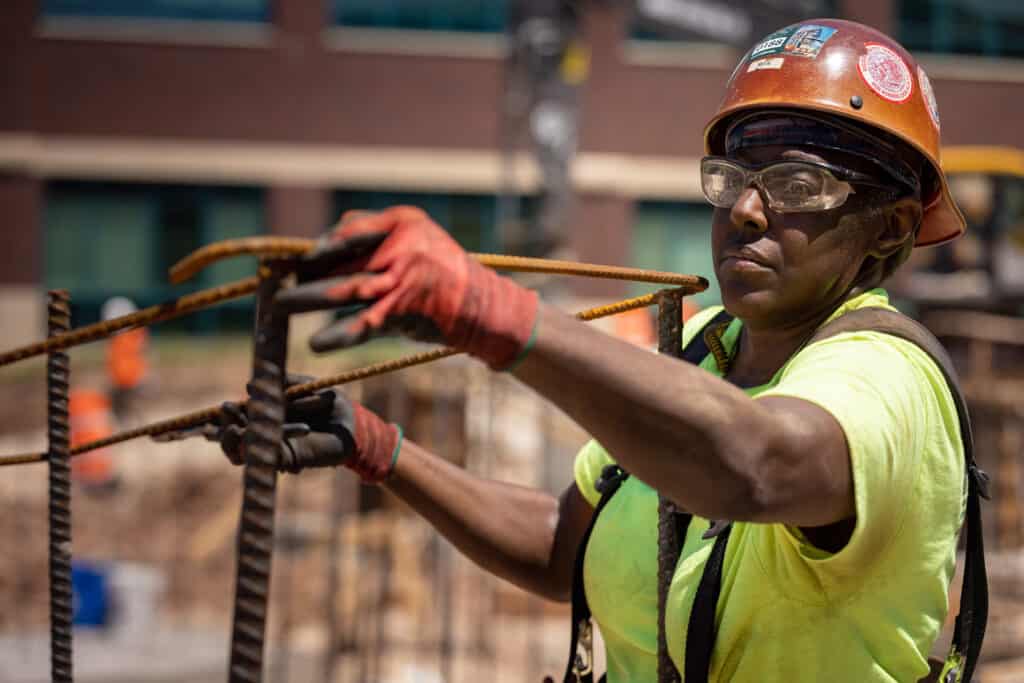 Construction worker assembles rebar structure on construction jobsite