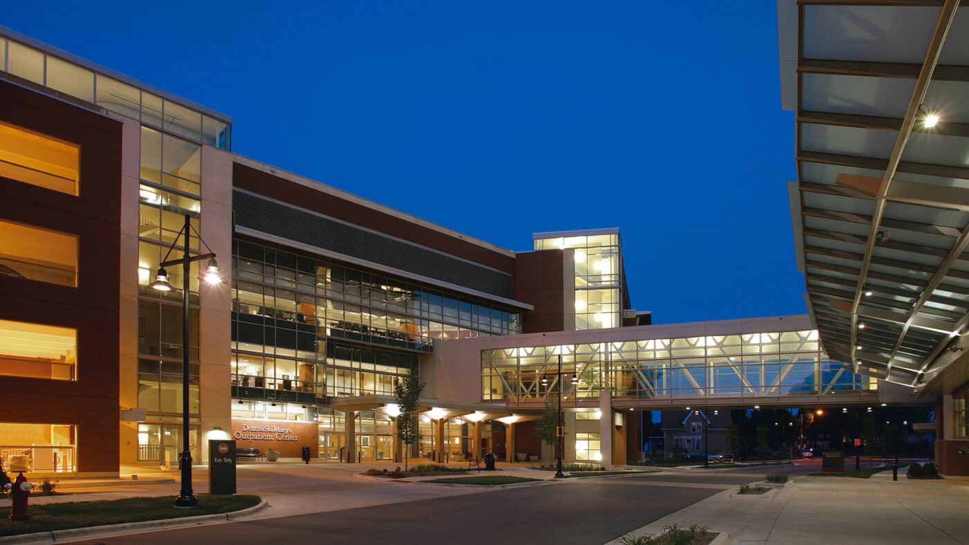 SSM Health - St. Mary's Hospital Campus - Outpatient Center and Parking and Exterior View of Building at Dusk with Skyway Connecting Two Buildings Lit