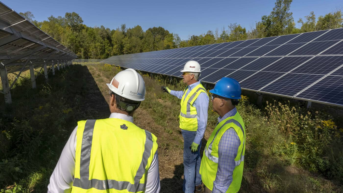 SunVest Solar - Chaska - 3 People in Safety Vests Viewing Solar Panels