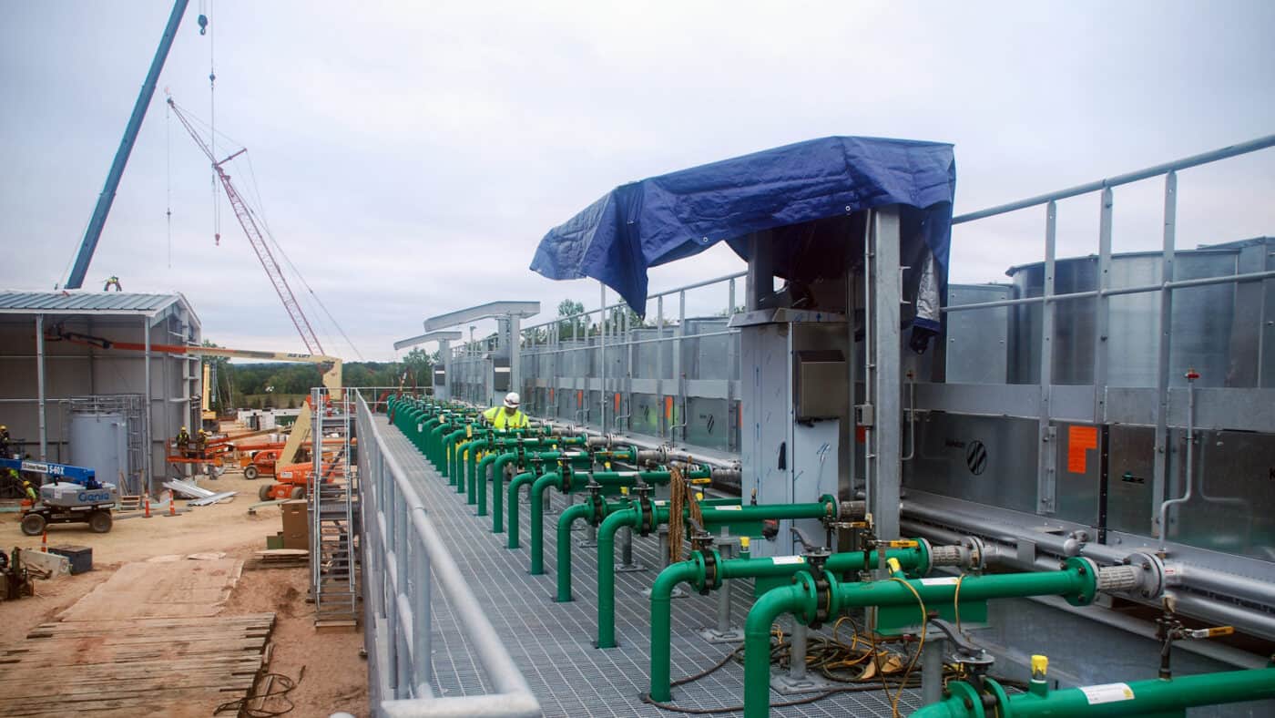 UMERC - Generating Station - Exterior of Construction Site with Cranes Visible in Background, Piping and Equipment Visible in Foreground