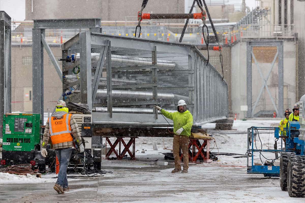 Crane lifting bridge and construction workers